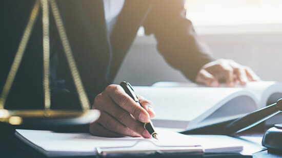 Justice and Law concept. Legal counsel presents to the client a signed contract with gavel and legal law or legal having team meeting at law firm in background